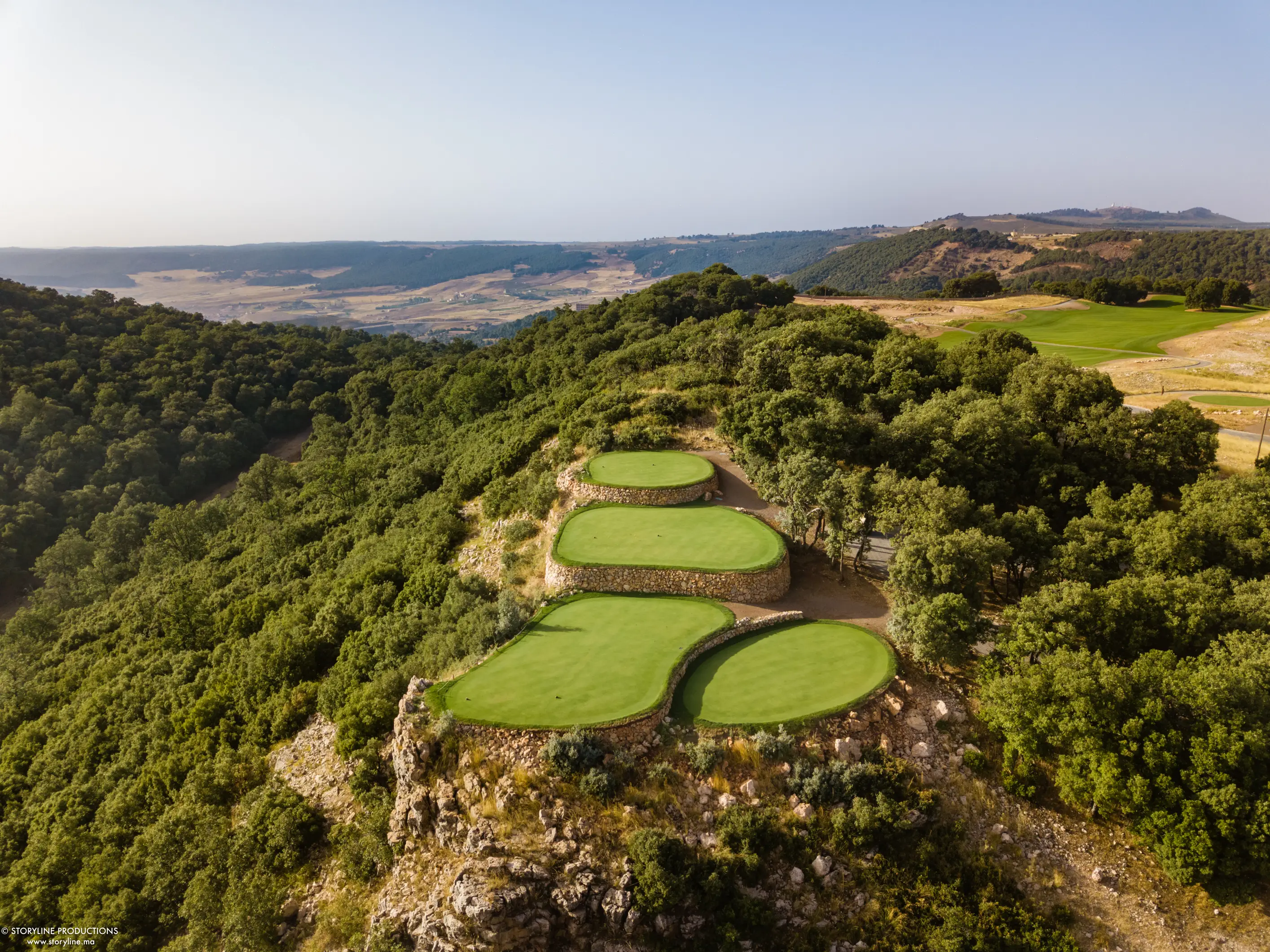 Tiered tee boxes on a forested ridge at Michlifen Golf & Country Club in Ifrane, in Morocco's Middle Atlas